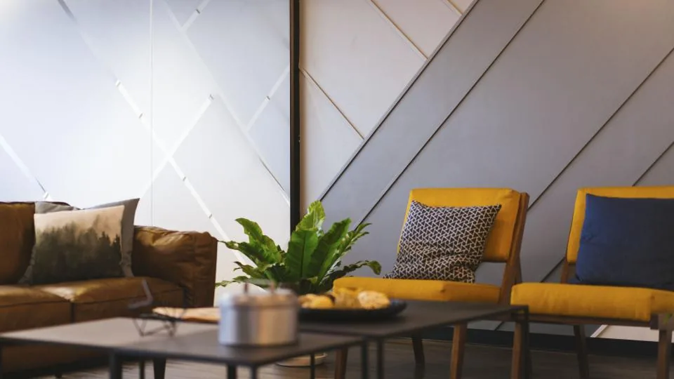 A tidy home corner with folded blankets and fresh flowers
